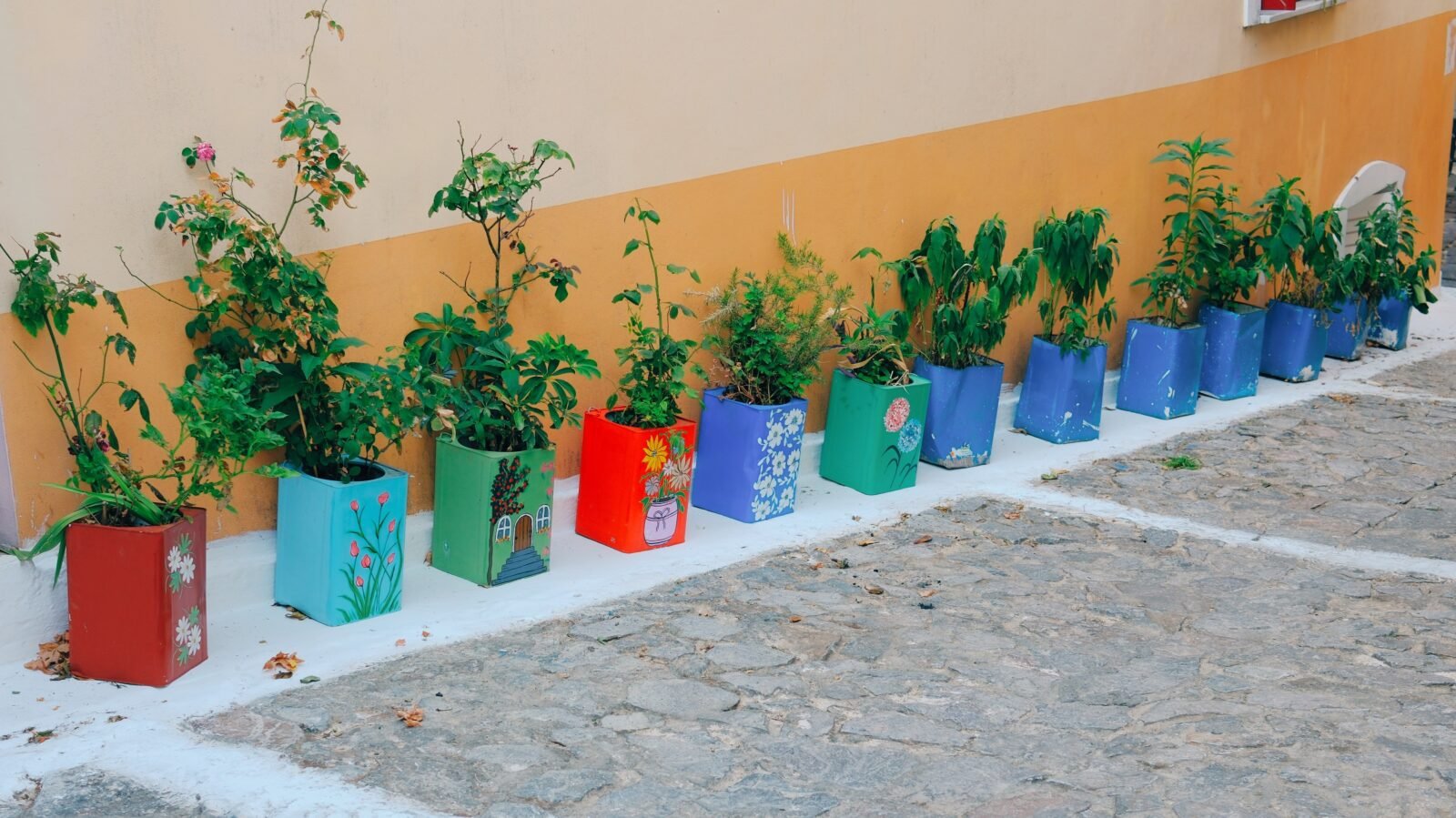 Colorful flower pots lining a street in Agiasos, Lesbos, Greece.