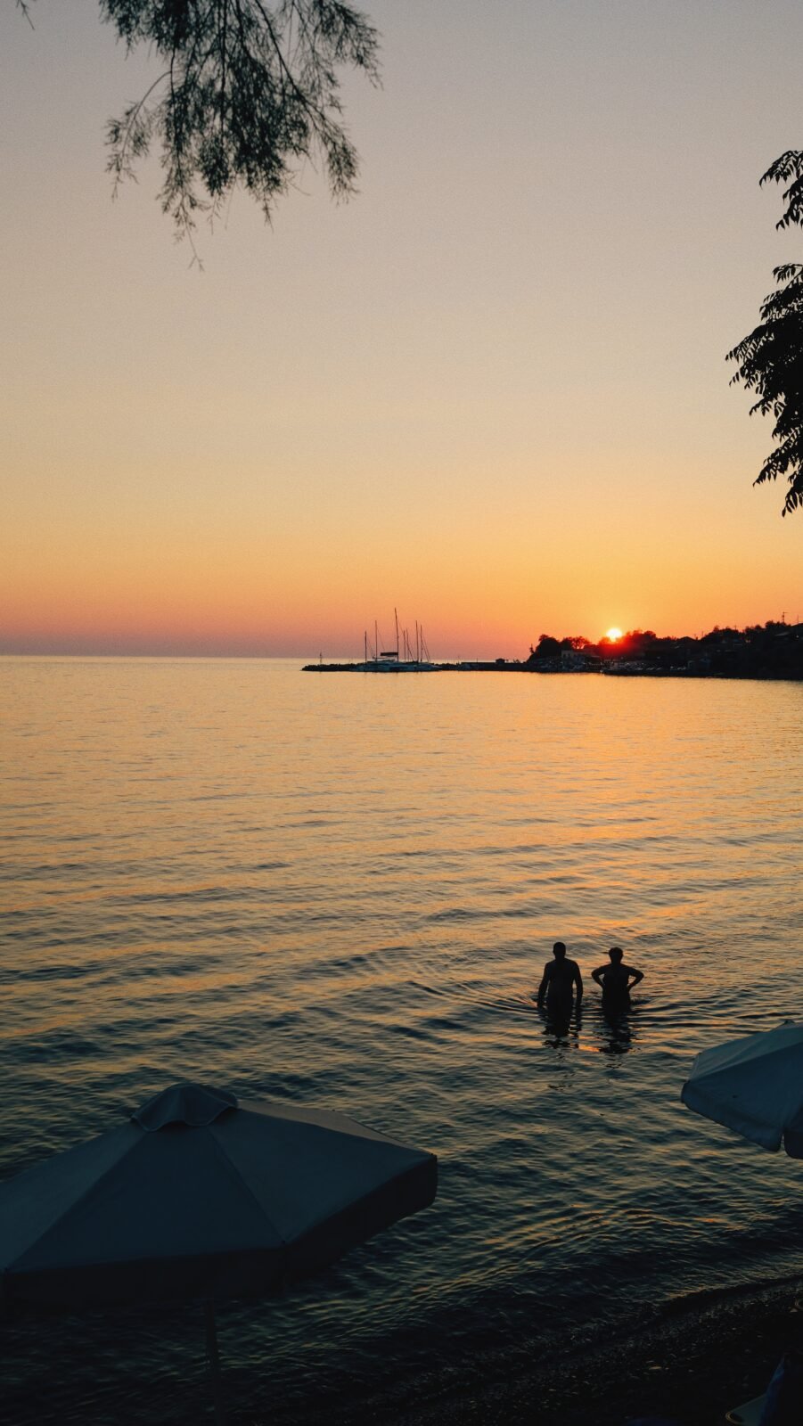 Couple swimming at sunset in Molyvos, Lesbos, Greece.