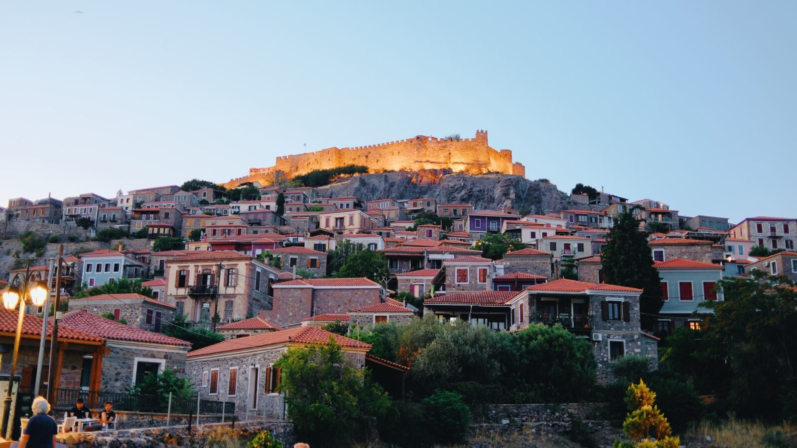 Castle atop the charming village Molyvos with buildings in the foreground during sunset, Lesvos
