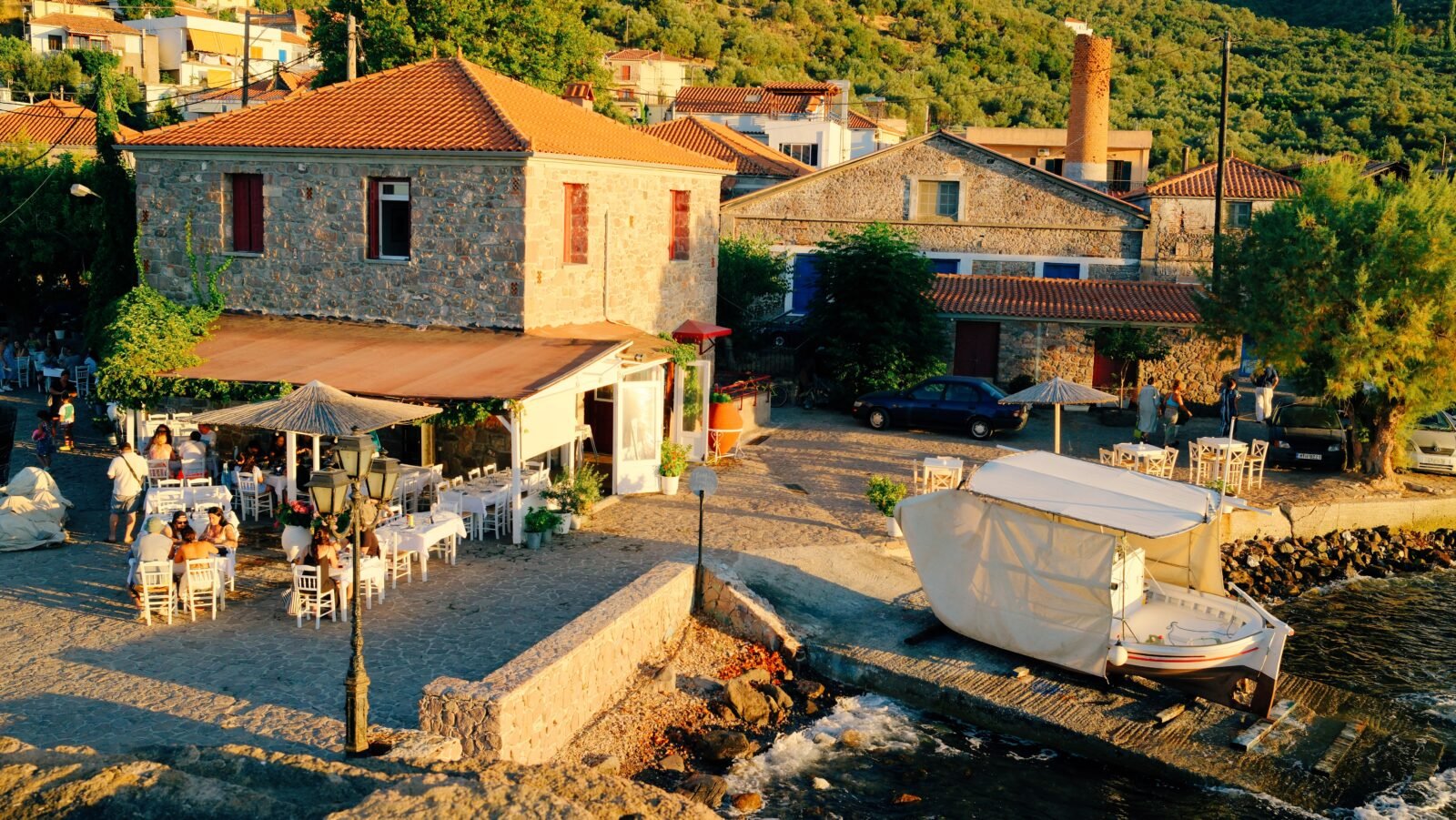 The small charming fishing village of Skala Sikamineas, with its harbour and waterfront restaurants at golden hour, Lesvos, Greece.
